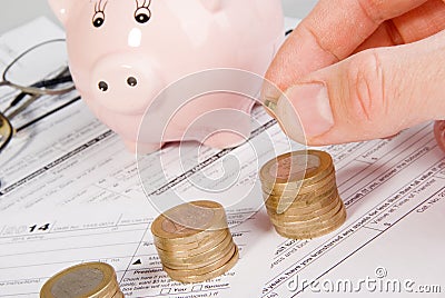 Male hand putting money on growing coin stack Stock Photo
