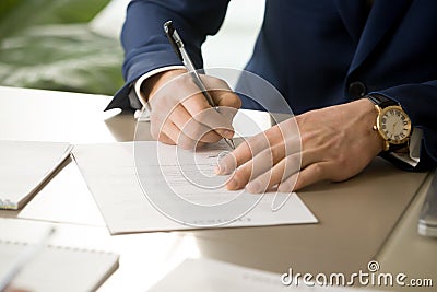 Male hand putting signature on contract, signing document, close Stock Photo