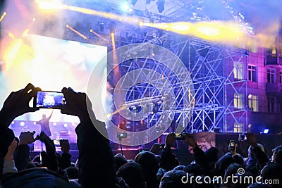 Male hand shoots video by smartphone during concert with laser s Stock Photo