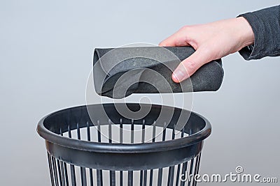 Discarding a Rolled Worn Mouse Pad into a Trash Bin Stock Photo