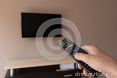 Control in Your Hands: Man Navigating Channels with TV Remote Stock Photo