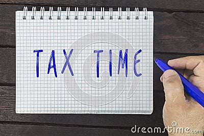 Male hand is writing Exam time on a notepad Stock Photo