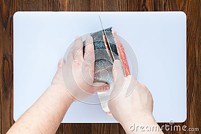 Male hands cutting piece of salmon Stock Photo