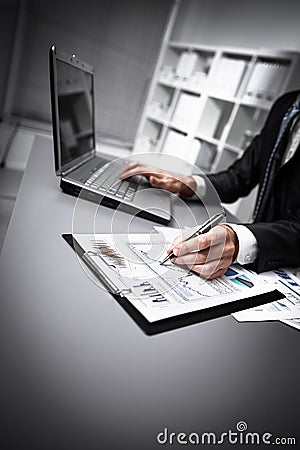 Male hands doing paperwork with pen and laptop. Stock Photo