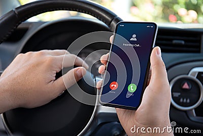 male hands driving car holding phone with incoming call screen Stock Photo