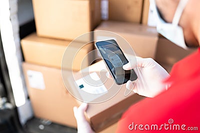 Male hands with gloves taking a picture of a shipping label Stock Photo