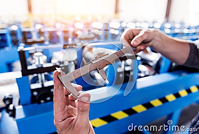 Male hands hold vernier caliper and measure steel collar. Stock Photo