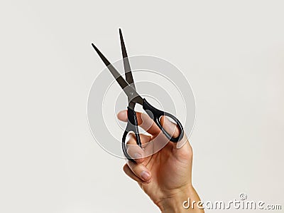 Male hands holding black scissors. on gray background. Stock Photo