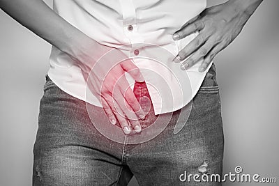 Male hands holding on middle crotch of trousers with prostate inflammation, Prostate cancer, Men`s health care concept Stock Photo