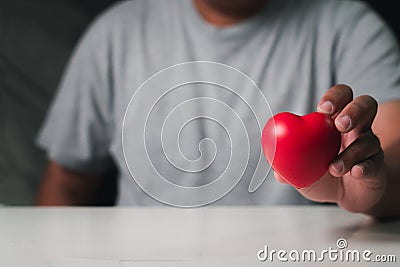 Male hands holding red heart, mental health Stock Photo