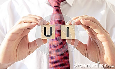 Male hands holding UI acronym, inscription on dices Stock Photo