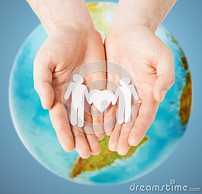 Male hands with paper gay couple figures and globe Stock Photo