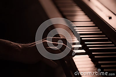 Male hands on the piano keys closeup of a beautiful colorful background Stock Photo