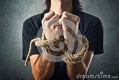 Male hands tied with a rope Stock Photo