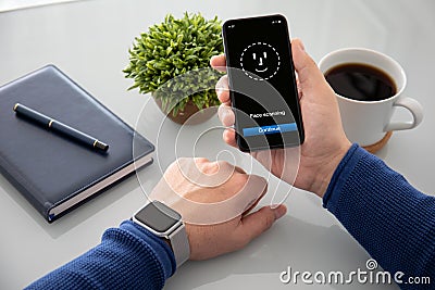 Male hands watch holding phone with face ID scanning Stock Photo