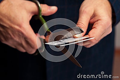 Male hands wirh scissors cutting bank credit card Stock Photo