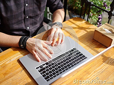 Male hands are working behind a laptop. Close-up. Stock Photo