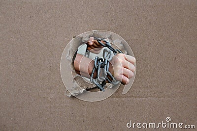 Male hands wrapped in a thick heavy iron chain, a symbol of the arrest of a criminal Stock Photo