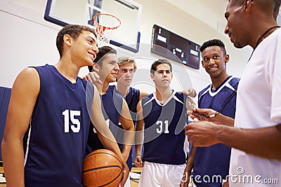 Male High School Basketball Team Having Team Talk With Coach Stock Photo