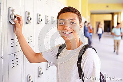 Male High School Student Opening Locker Stock Photo