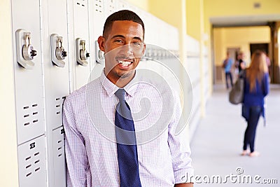 Male High School Teacher Standing By Lockers Stock Photo