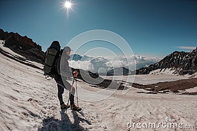 Male hiker stands on the mountain sides Stock Photo