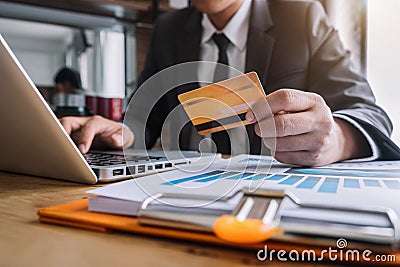 Male hold credit cards, conduct financial transactions via tablets and data documents. Stock Photo