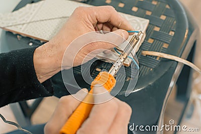 Male holding soldering iron tool repairing, electrical wire connection, soldering with a soldering iron Stock Photo