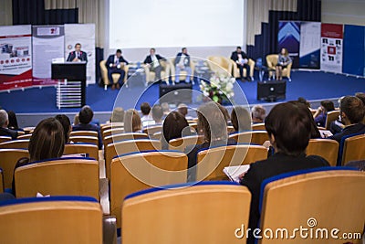 Male Host Speaking On Stage During Business Conference in Large Congress Hall. Stock Photo