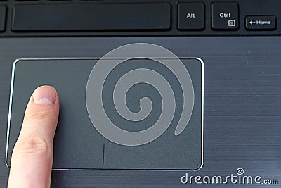 Male index finger on a laptop trackpad Stock Photo