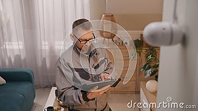 Installer sets up security camera using tablet Stock Photo