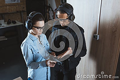 male instructor describing gun to female customer Stock Photo