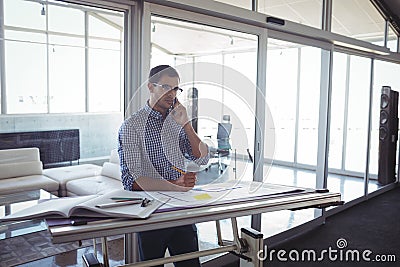 Male interior designer talking on mobile in office Stock Photo