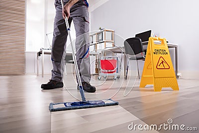 Male Janitor Cleaning Floor In Office Stock Photo