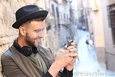 Male laughing while texting outdoors Stock Photo