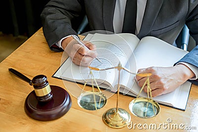 Male lawyer working with contract papers and reading law book in a courtroom, justice and law concept while presiding over trial Stock Photo
