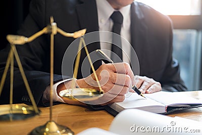 Male lawyer working with contract papers and reading law book in a courtroom, justice and law concept while presiding over trial Stock Photo