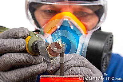 Male locksmith worker processes metal with engraving drill cutting. The work of the dremel engraving electric tool. Industrial Stock Photo