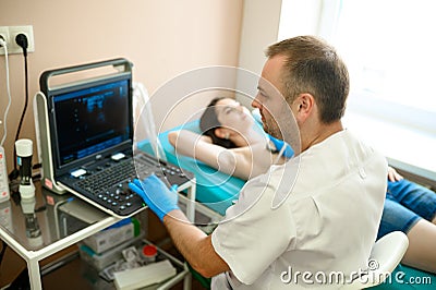 Male mammologist makes breast ultrasound scanning Stock Photo