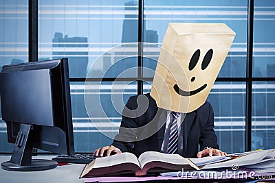 Male manager with cardboard head working in office Stock Photo