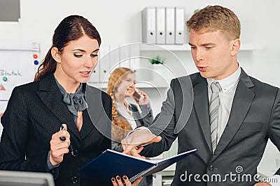 Male manager instructs female employee in office Stock Photo