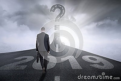 Male manager walks toward question mark Stock Photo