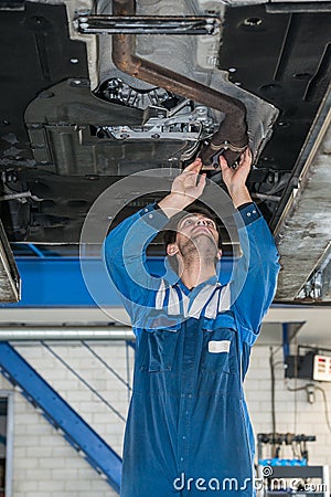 Male Mechanic Examining Exhaust System Of Car Stock Photo