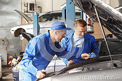 Male mechanics fixing car in service center Stock Photo