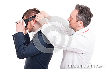 Male medic putting vr device on manager head Stock Photo