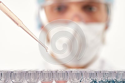 Pharmacist dropping test liquid into multiple cells Stock Photo