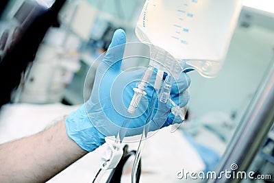 Male medical worker regulate the intravenous drip system at the Stock Photo