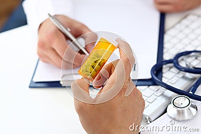 Male medicine doctor write prescription at worktable Stock Photo