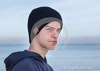 Male model wearing black knitted beanie with Bluetooth speakers inside Stock Photo
