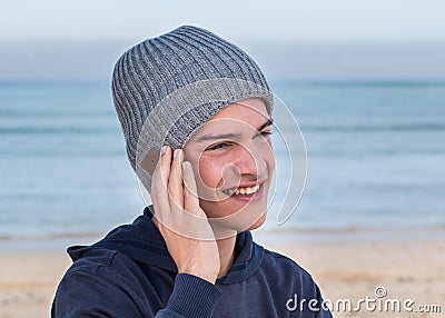 Male model wearing gray knitted beanie with Bluetooth speakers inside Stock Photo